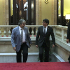 Imagen de archivo del expresidente de la Generalitat, Carles Puigdemont, entrando en el Parlament con Joaquim Nin.