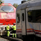 Operarios de Adif y de Renfe haciendo tareas para retirar la locomotora accidentada en el choque con un tren regional en Vila-seca.