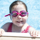 Una nena gaudint d'una activitat d'estiu a la piscina.