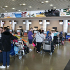 Imatge d'arxiu de l'aeroport de Reus amb persones a la cua de facturació.
