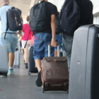 Turistas con maletas a la salida del aeropuerto del Prat.