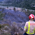 Un bombero observa la zona calcinada al barranco de *Povet, al término municipal de Tortosa.