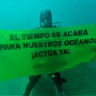 Un activista de Greenpeace despliega una pancarta submarina en la Mar Bella.