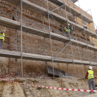 Operaris treballant en la recuperació de l'antiga muralla de Sant Antoni de Valls, on s'ha instal·lat una gran bastida.