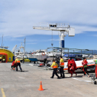 Els equips d'emergències atenent els afectats en el simulacre d'incendi en un catamarà al port de Cambrils.
