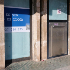 El lateral de una antigua bancaria en Segur de Calafell, actualmente cerrada y con un cartel de venta o alquiler.
