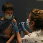 Un niño poniéndose la vaccinia contra la covid-19 en Girona.