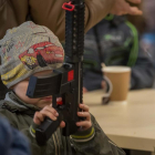 Un nen juga amb una metralleta de joguina a una de les sales de l'estadi Arena Lviv reconvertides en allotjament per a desplaçats a Leópolis.