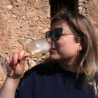 Una mujer bebiendo una copa de vino.