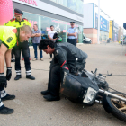 Un Mosso d'Esquadra ensenya a aixecar una moto de forma segura a un usuari de la jornada.