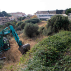 Una màquina excavadora treballant en les obres d'ampliació de l'aparcament municipal de Torroja.