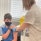 Una enfermera administra a un niño la segunda dosis de la vacuna contra la covid-19.