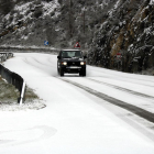 Un coche circulando por una carretera nevada.