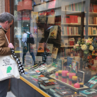 Un home mira l'aparador d'una llibreria de Reus el dia previ a la Diada de Sant Jordi.