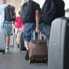 Turistes amb maletes a la sortida de l'aeroport de Reus.