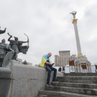 Un home amb la bandera d'Ucraïna a la plaça de la Independència de Kíev.
