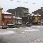 Diverses cases de Sant Hilari Sacalm enfarinades i una plaça amb la neu mig fosa per la pluja.