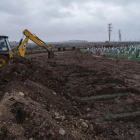 Una excavadora prepara lloc digs graves for victims of the earthquake at a cemetery in Diyarbakir