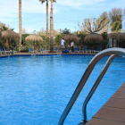 Dos operaris preparen la piscina de l'Hotel Sol Cambrils just abans de l'inici de Setmana Santa.