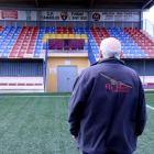 Un membre del club de futbol de Camarles mirant el crespó negre col·locat a les grades.