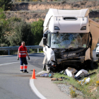 Un operari retira les restes del vehicle que han quedat davant del camió accidentat a Batea.