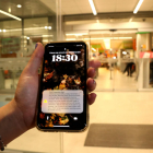 Una vecina muestra el mensaje recibido en el teléfono móvil para iniciar el simulacro a las puertas de un supermercado de La Canonja.