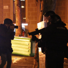 Un periodista fotografía a un agentes de los Mossos con una lanzadera foam.