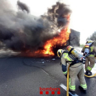Dos bombers treballen en l'extinció d'un camió incendiat a l'AP-7, a Vilafranca del Penedès.