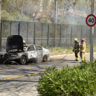 El vehicle cremat al costat de la via.