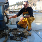Un pescador mostrando algunos de los desechos recogidos en su embarcación.