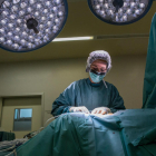 Pla mitjà d'una infermera fent una sutura en una intervenció en un quiròfan hospitalari.