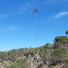 Operaris d'Endesa fent tasques de manteniment en una zona boscosa del Priorat amb la intervenció d'un helicòpter.
