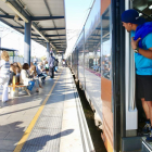 Un usuari treu el cap en un tren de Rodalies aturat a l'estació de Gavà.