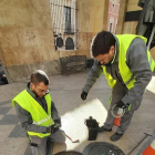 Dos operarios de Aigües de Reus realizando la inspección de una alcantarilla en Reus.
