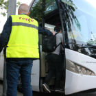 Un treballador de Renfe indica als passatgers pujar al autobús.