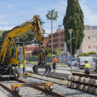 La grua amuntegant les travesses ahir al matí, en la part del traçat pròxim a l'antiga estació.