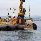 Dos operaris submergint un dels últims biòtops que vorejaran la primera muntanya marina construïda al Port de Torredembarra.