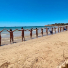Una vintena d'usuaris van participar en la cadena humana del Club Català de Naturisme a la platja de la Savinosa.