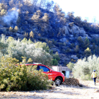 Un vehicle i un agent dels Bombers davant d'una zona cremada del Puig Moltó del Perelló encara fumejant.