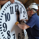 Un operario a punto de colocar el reloj en la fachada del consistorio de Tarragona.