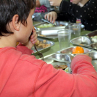 Imatge d'arxiu d'alumnes asseguts a una taula dinant en el menjador d'una escola.