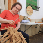 Una cistellera elabora una bossa feta amb fibres de paper.