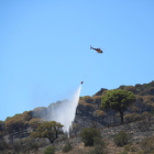 Un helicòpter descarregant en un dels focus de l'incendi de Portbou.