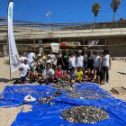 Els membres de les diferents organitzacions amb la brossa que han recollit de la platja del Miracle.