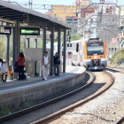 Passatgers esperant a l'andana l'arribada d'un tren a l'estació de Rodalies de Gavà.