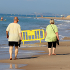 Dos personas paseando por la playa de Altafulla.