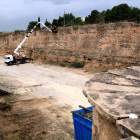 Operaris netegen amb una grua les muralles del fossar del Sitjar on es treballa per construir un aparcament provisional de l'HTVC.