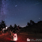 Un dels telescopis del Parc Astronòmic i persones contemplant el cel nocturn.