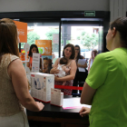 Dos profesionales atendiendo a una madre en una farmacia de Tarragona adherida al servicio de asesoramiento Alletafarma.