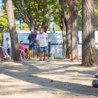 Alguns participants aprofiten per exercitar-se a l'ombra dels arbres, entre les pistes i el local social.